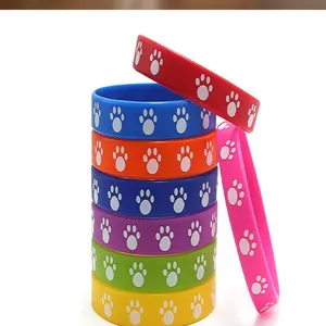 Detailed view of multiple colorful silicone wristbands featuring white cat paw print patterns