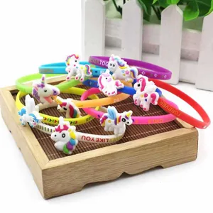 Dettaglio ravvicinato di braccialetti in silicone colorati con unicorni e scritte.