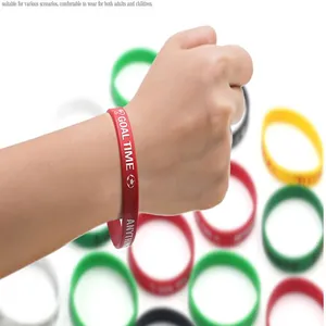 Detailed view of a red silicone football sports wristband with Goal Time printed logo on a hand