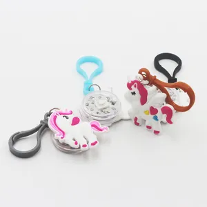 Dettaglio dei portachiavi unicorno in PVC con luci LED e clip in plastica colorate