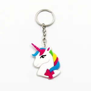 Nahaufnahme eines weiß leuchtenden PVC Einhorn Schlüsselanhängers mit bunter Regenbogenmähne