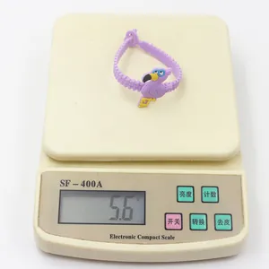 Dettaglio del leggero bracciale in PVC con fenicottero viola da 5,6 g sulla bilancia.