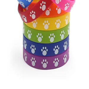 Detailed macro view of colorful silicone wristbands with embossed white paw print motifs