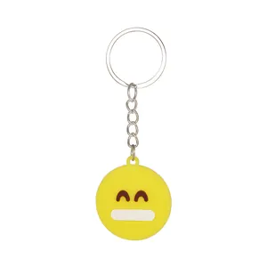 Dettaglio di portachiavi emoji giallo con anello in metallo e faccia sorridente