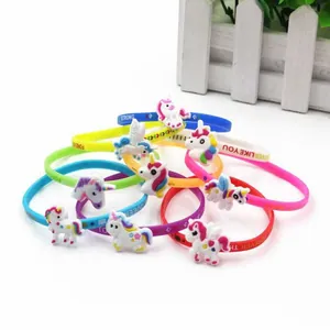 Dettaglio di braccialetti in silicone colorati con unicorno e scritte in inglese.