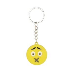 Dettaglio di un portachiavi emoji giallo in silicone con design a bocca a X