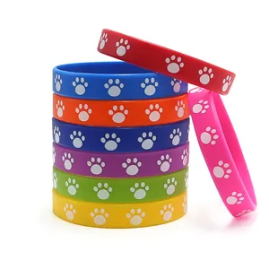 Set of vibrant colorful silicone wristbands featuring adorable white paw print patterns