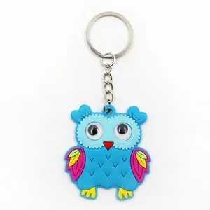 Close-up detail of a cute blue PVC owl keychain featuring vibrant colorful wing accents.