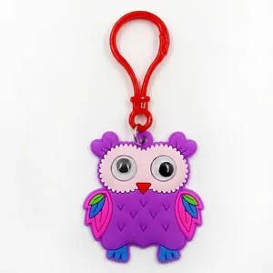 Close-up of a purple cartoon owl keychain made of soft PVC with a red plastic clip.