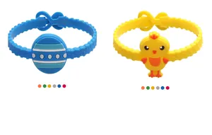 Dettaglio dei braccialetti pasquali in silicone con motivi di uova e pulcini colorati.