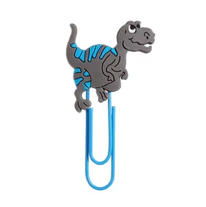 Detailansicht eines grauen PVC-Cartoon-Dinosaurier-Lesezeichens an einer blauen Büroklammer