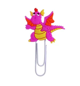Makroansicht einer lila Cartoon-Drachen-PVC-Dekoration an einer weißen Büroklammer
