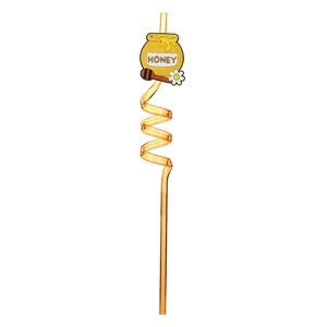 Close-up detail of spiral orange drinking straw with cute honey pot cartoon accessory