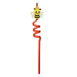 Close-up detail of an orange spiral straw featuring a cute cartoon bee crown accessory topper.
