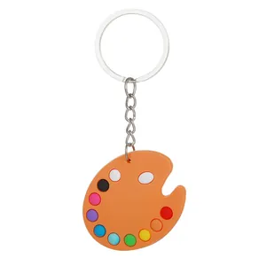 Vista dettagliata di un portachiavi a tavolozza da pittore in PVC arancione con punti colorati.