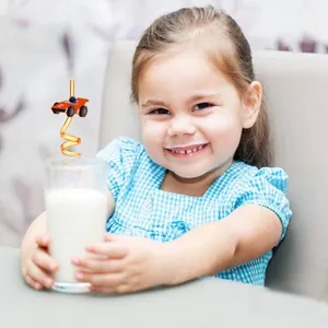 Petite fille tenant un verre de lait avec une paille créative en spirale avec voiture de course