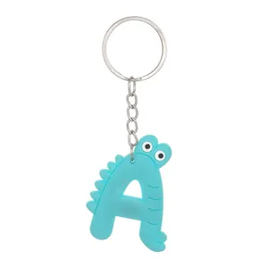 Detailed view of a blue PVC keychain shaped like a cartoon dinosaur letter A