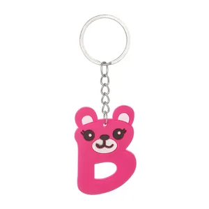 Close-up of a pink PVC alphabet B animal bear keychain with silver metal ring