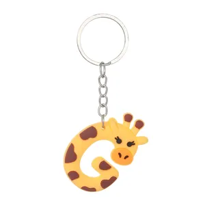 Detailed macro view of a cute yellow PVC giraffe-shaped letter G keychain with ring.