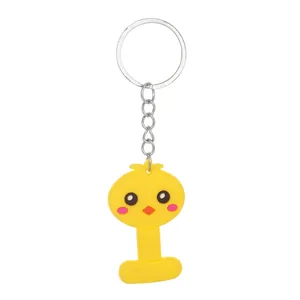 Detail view of yellow PVC letter I keychain with a cute cartoon chick face design