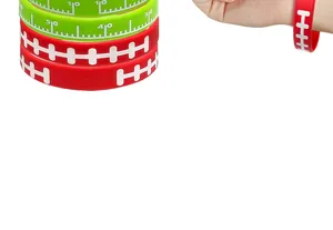 Close-up of red and green silicone football wristbands with yardage and lace patterns