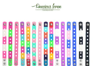 Detail view of various colorful adjustable silicone wristbands with hole patterns