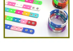 Detail shot of various colorful adjustable silicone wristbands with holes and snaps.