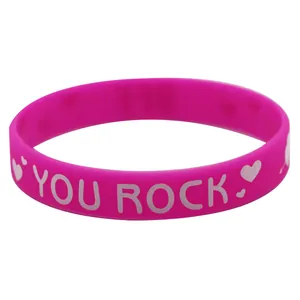 Rosafarbenes Silikonarmband mit weißem "YOU ROCK" Text und Herzmustern.