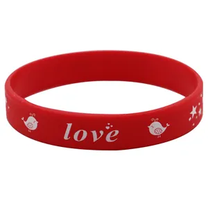 Detailansicht eines roten Silikonarmbands mit weißem Love-Schriftzug und Vogelmuster.