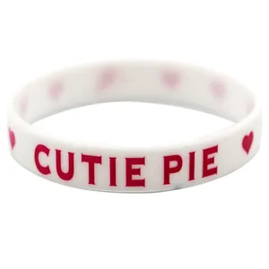 Nahaufnahme des weißen Silikon-Valentine-Armbands mit rotem Cutie Pie-Text und Herzen