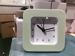 Close-up of a minimalist light green square alarm clock with clear black numbers
