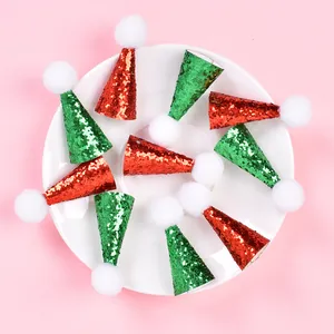 Detailed view of ten mini red and green glitter Christmas hats for small pets on a plate