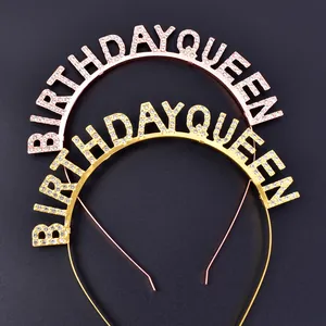 Detail of gold and silver Birthday Queen rhinestone headbands on black background