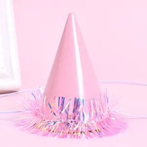 Close-up detail of a pink miniature pet party hat with iridescent tinsel fringe accents