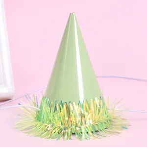 Detail of mini green pet party hat with iridescent tinsel fringe and elastic strap