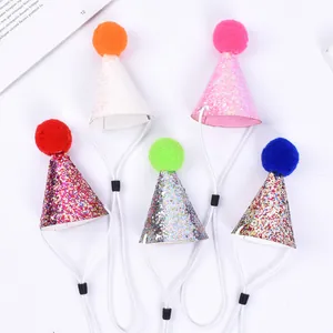 Close-up view of five colorful glitter pet party hats with pom-poms and adjustable straps.