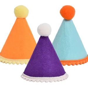 Set mit drei farbenfrohen Filz-Partyhüten für Haustiere mit Pompons und Spitzenrand.