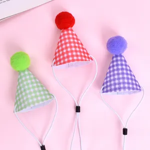 Détail de chapeaux de fête pour animaux à carreaux avec pompons colorés et lanières