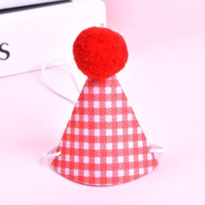 Gros plan d'un chapeau de fête pour animaux avec motif à carreaux rouges et pompon