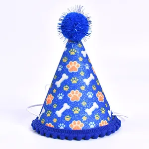 Détail d'un chapeau de fête bleu scintillant pour animaux avec motifs de pattes et d'os