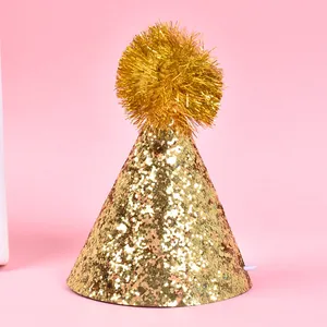 Close-up of golden glitter pet party hat with fluffy pom-pom detail for birthdays