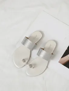 Vue détaillée de sandales plates blanches élégantes avec strass brillants et bride argentée
