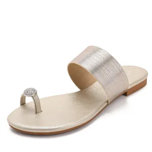Sandales plates dorées élégantes pour femmes avec strass brillants et détail d'anneau.