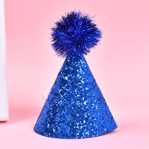 Detailed macro view of vibrant blue glitter pet birthday hat featuring a fluffy pom-pom top