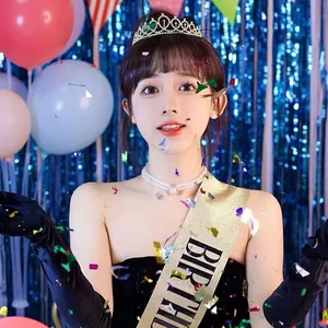 Jeune fille portant un diadème d'anniversaire scintillant et une écharpe dorée de fête