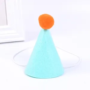 Primo piano di un cappello da festa in feltro azzurro per animali con pompon arancione.