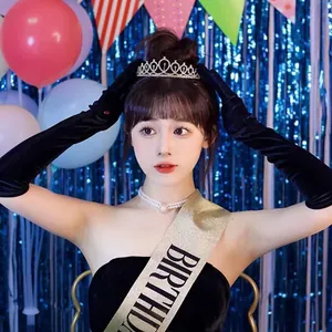Fille asiatique portant un diadème d'anniversaire étincelant et une écharpe dorée en fête