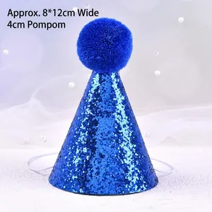 Close-up view of a blue glittery pet birthday hat with a blue pom-pom and strap.