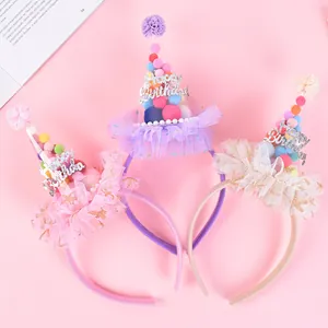 Detail of birthday headbands with colorful pom-poms, glitter text, and mesh ruffles