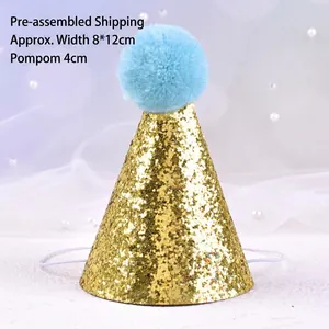 Close-up detail of a gold glitter pet birthday hat with a fluffy light blue pom-pom.